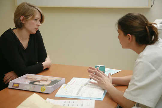 A pregnant woman talking to her health care provider.  (why the fda is warning pregnant women not to use over the counter pain relievers)