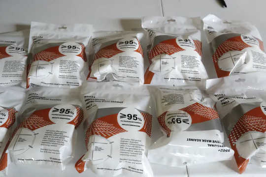 A table with various brands of KN-95 masks in packaging