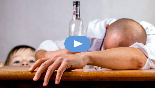 Can LSD Cure the 'Spiritual Disease' of Alcoholism? man passed out on a table with an empty bottle of alcohol with child looking on