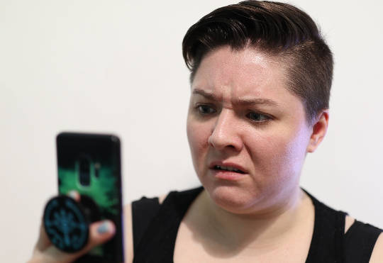 Getting the Upper Hand Over Impatience woman looking at her phone with a look of disgust on her face