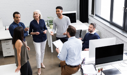 Personal and Leadership Values To Live By a group of workers in an office talking and smiling