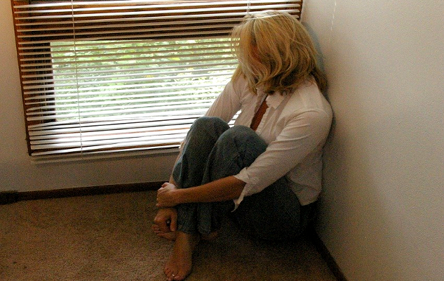 False Belief: It Is Weak to be Afraid woman sitting on the floor looking out through the cracks of a venetian blinds of a window