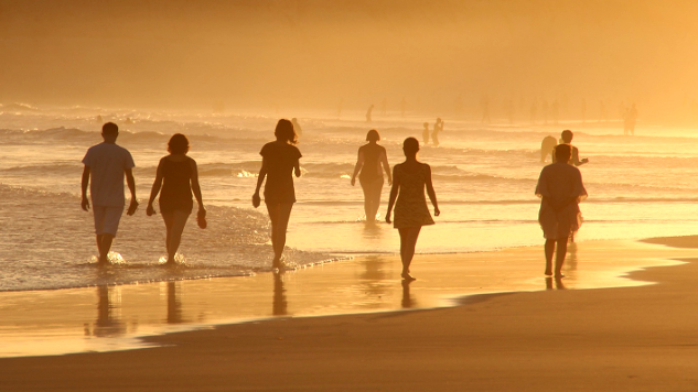 Walking On Sacred Ground and Restoring Health people walking barefoot in the water's edge on the beach