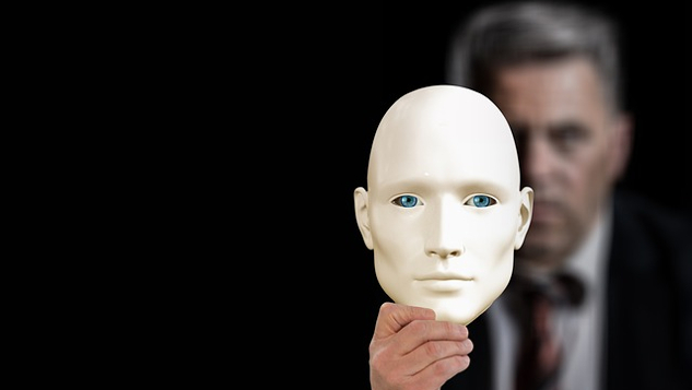Are We Moving Towards Connection? man holding up a mask in front of him