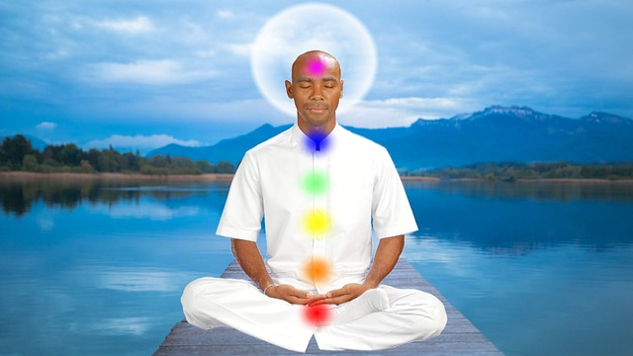 Esoteric Healing: What, Who, When, Where, and Why a man sitting in meditation with chakras lit up