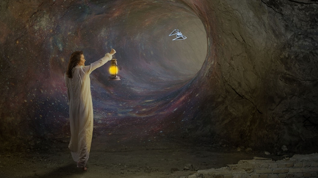 The Ideal? Living in Peaceful Unity -- The Problem? The Ego-Based Mind a young woman holding a lantern in a dark wormhole-like cave