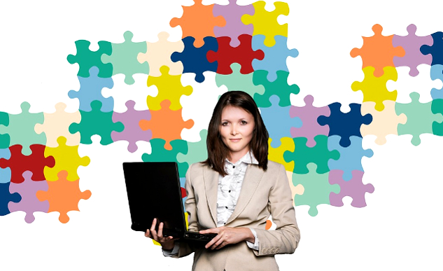 Feeling Like Something Is Off? Are Your Basic Needs Being Met? woman holding a laptop with a background of puzzle pieces on the wall behidn her