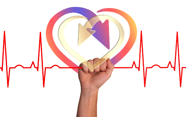 The Secrets to Healing from Long-Haul COVID a hand holding a drawing of a heart in victory