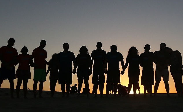 What Will We Do Next? a group of people in line at the horizon, holding hands