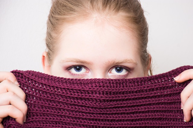 InnerSelf Magazine: March 31, 2025 Young woman hiding half of her face behind a knitted cloth. Image by Anemone123 from Pixabay.